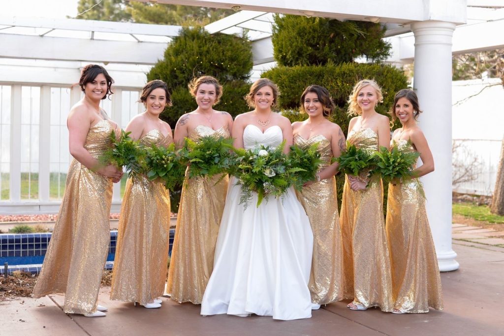 Wedding party with floral bridal bouquet and greenery bridesmaids
